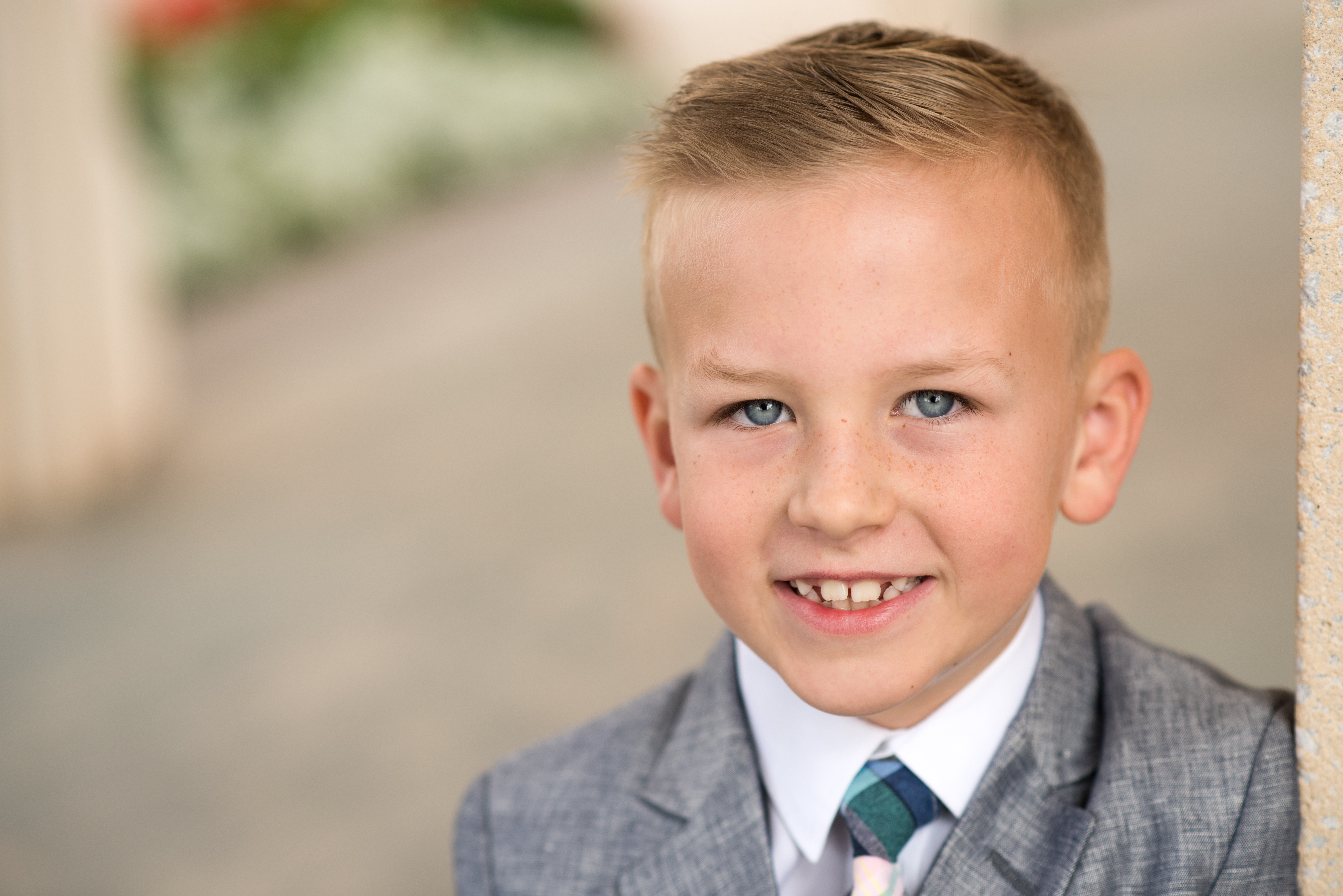 Eight year old boy in suit for baptism portraits at the Gilbert Arizona LDS Temple. Photographer Melissa Maxwell of Jubilee Family Photography.